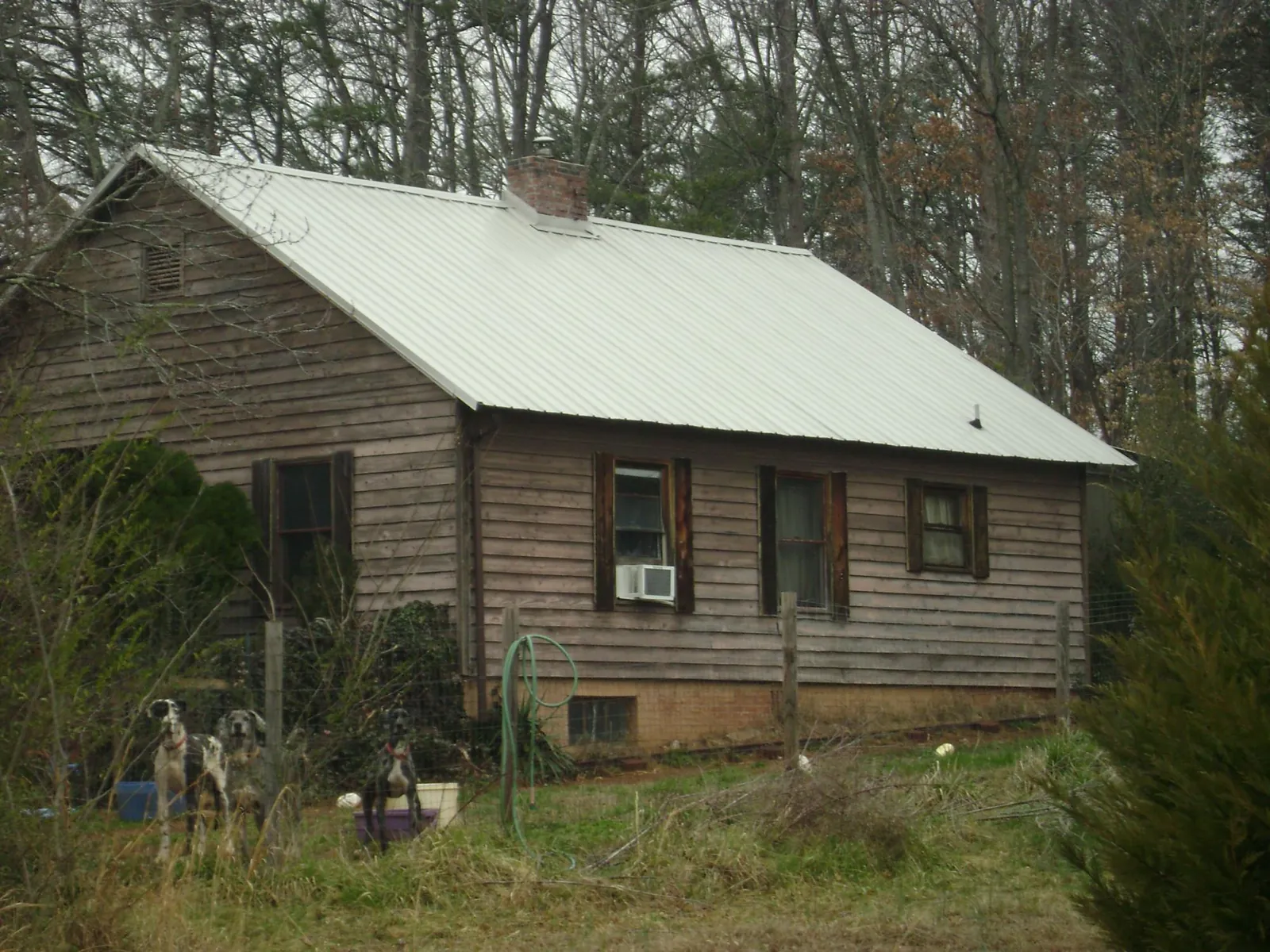 White metal roof on an old wood sided farmhouse, from a Asphalt Shingle Roof Repair job in Highland